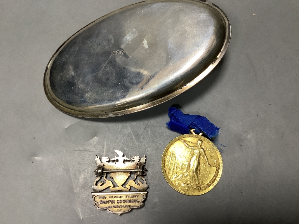 A Chinese white metal oval pen rest, 11.7cm and an Edwardian Coronation Celebration medallion.